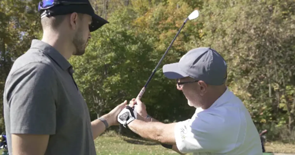 a man teaching a guy how to swing