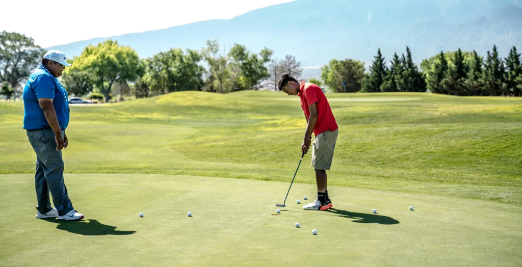 Two golfers practicing on green